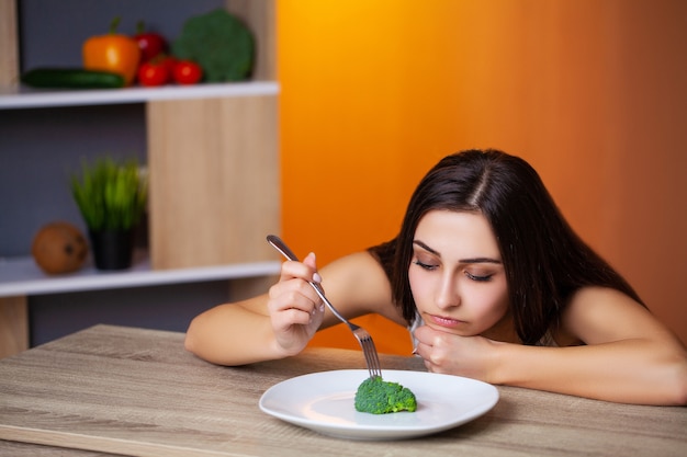 Cute woman adheres to her diet and eats only fresh vegetables and fruits