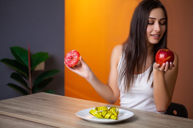 Cute woman adheres to her diet and eats only fresh vegetables and fruits.