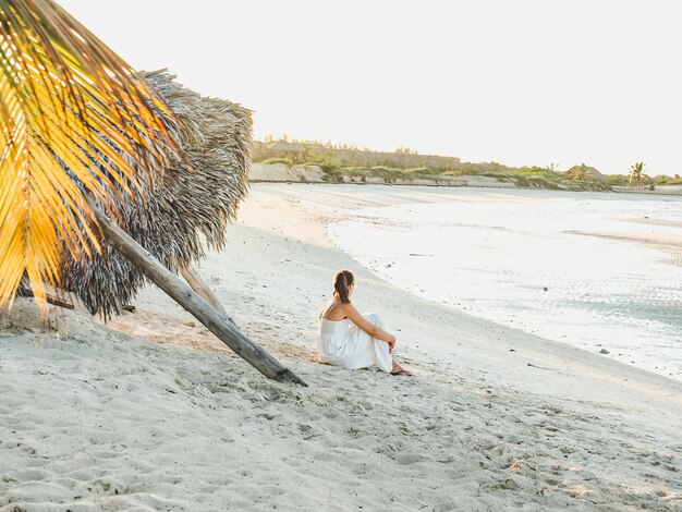 Cute woman on the beach against the background of the sea