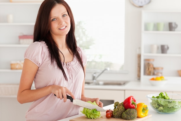 Cute woman cutting vegetables