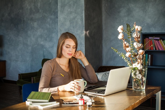 Cute Woman Drinking Coffee. Coffee Break during the Working Day