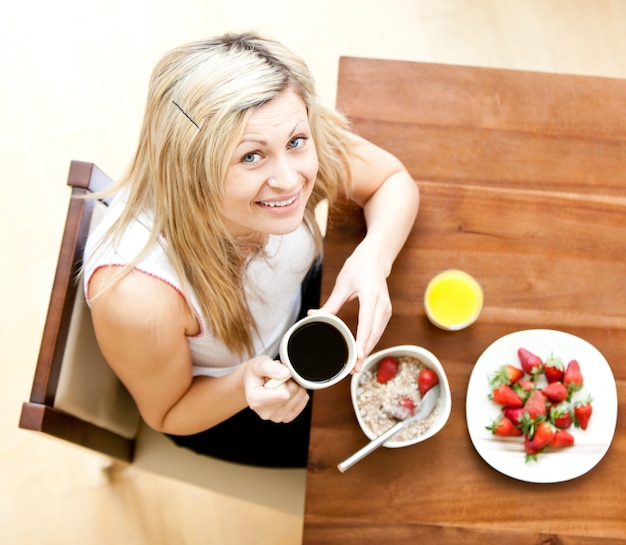 Cute woman having an healthy breakfast in a livingroom 