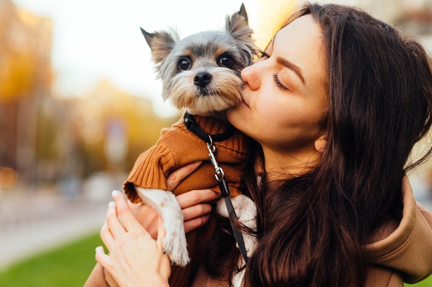 かわいい小さな犬にキスするかわいい女性のクローズアップの肖像画