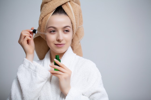 Симпатичная женщина делает макияж в лицо в ванной