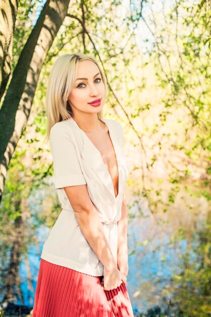 Cute woman outdoors on green foliage leaves background