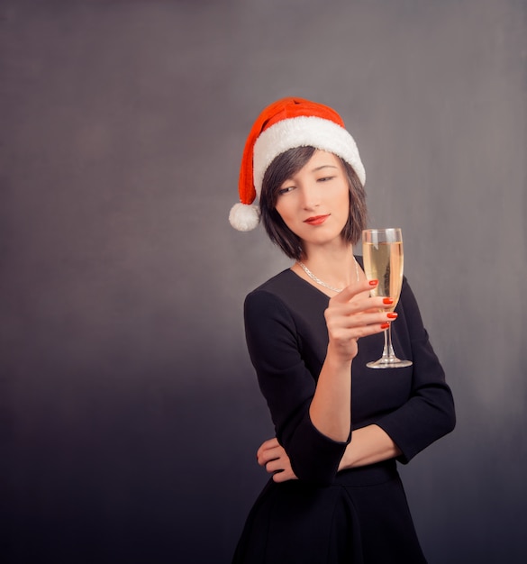 Cute woman in santa hat with drink