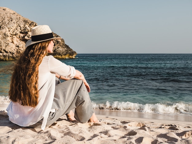 Cute woman sitting on an empty beach