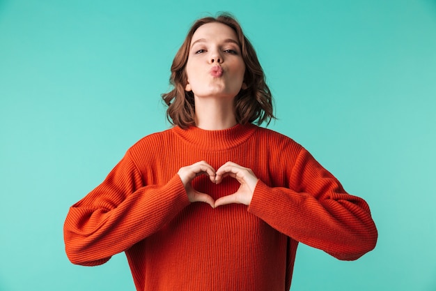 Cute woman standing isolated make heart gesture.