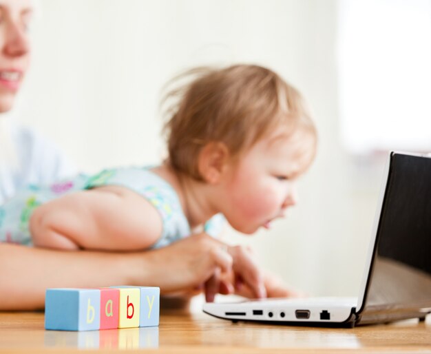 Cute woman surfing on the internet with her girl in the living-room 