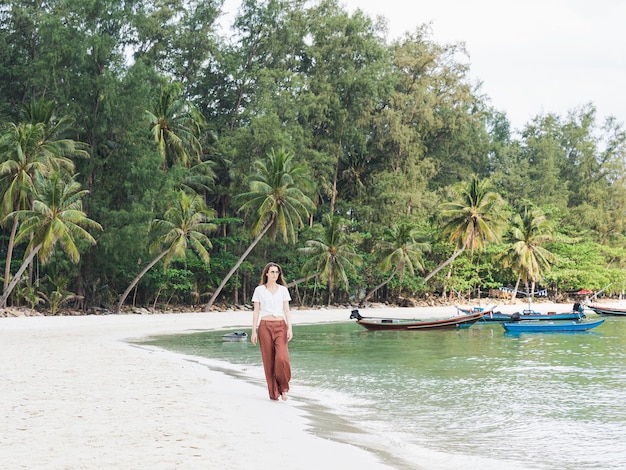 Cute woman walking along a stunning white sandy beach