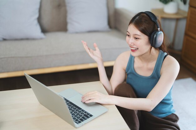 Photo cute woman wear wireless headset video conference calling on laptop computer talk by webcam
