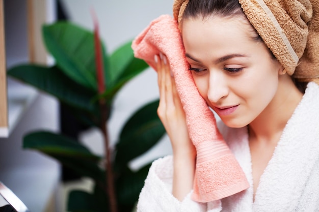 Cute woman wipes the face towel after taking a shower