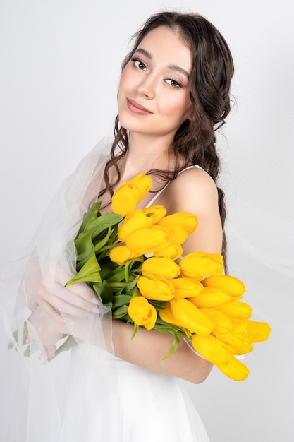 Cute woman with bouquet of yellow tulips