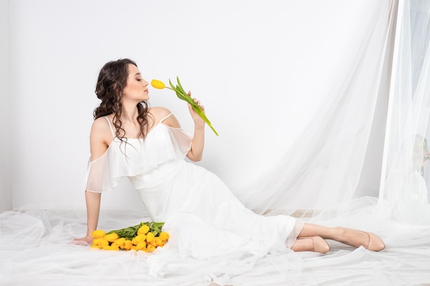 Cute woman with bouquet of yellow tulips