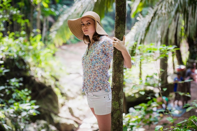 Cute woman with a hat posing in the forest