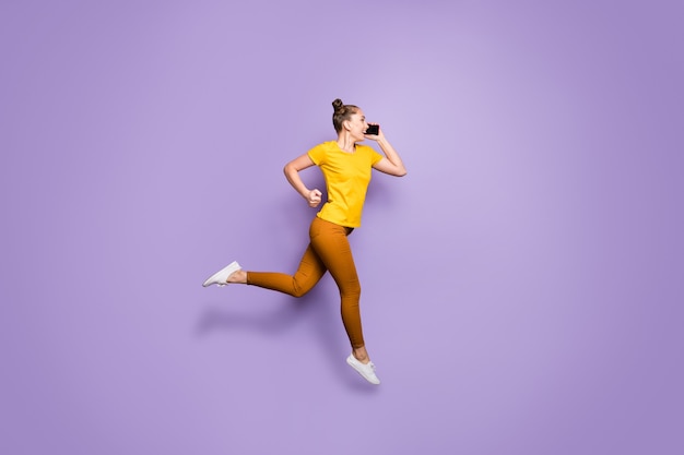 Cute woman with topknots posing against the purple wall