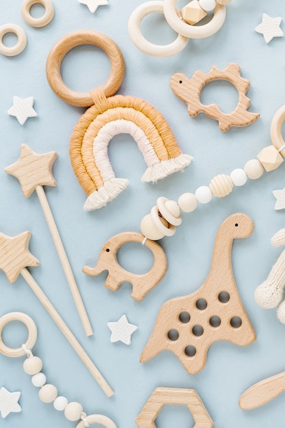 Foto simpatici giocattoli per bambini in legno. orso lavorato a maglia, arcobaleno, giocattolo di dinosauro, perline e stelle.