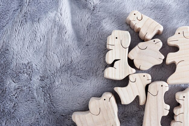 Cute wooden toy animals on fluffy fabric