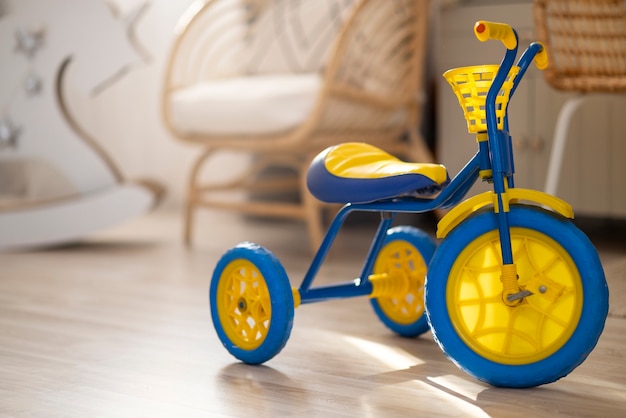 Photo cute yellow and blue tricycle indoors