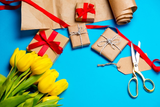 Cute yellow tulips, beautiful gifts and cool things for wrapping on the wonderful blue background