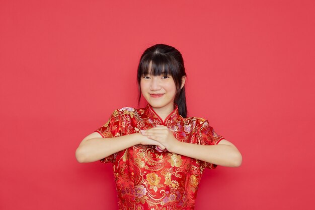 귀여운 젊은 아시아 여자 중국 새 해 개념에 대 한 조치와 함께 치파오를 착용