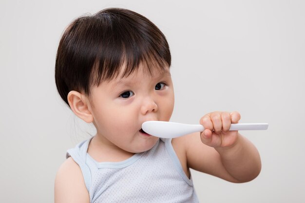 Cute young baby boy pick a spoon