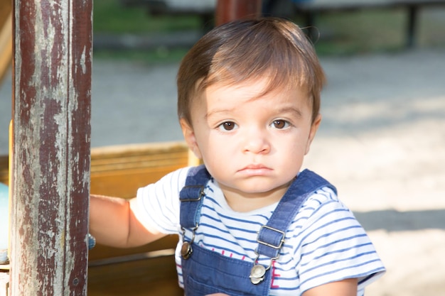 Cute young boy playing on playground in garden park