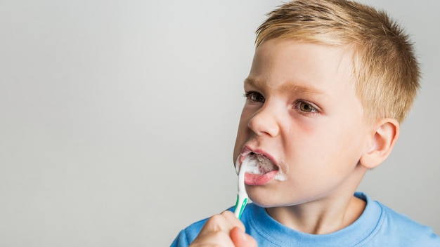 Foto spazzolatura di denti sveglia del giovane ragazzo