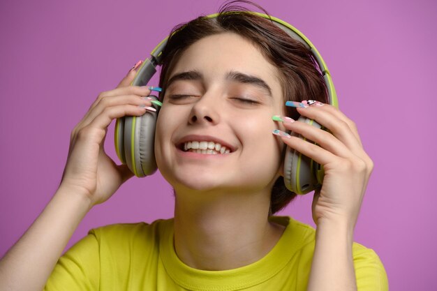 Cute giovane bruna divertirsi ascoltando musica utilizzando le cuffie wireless