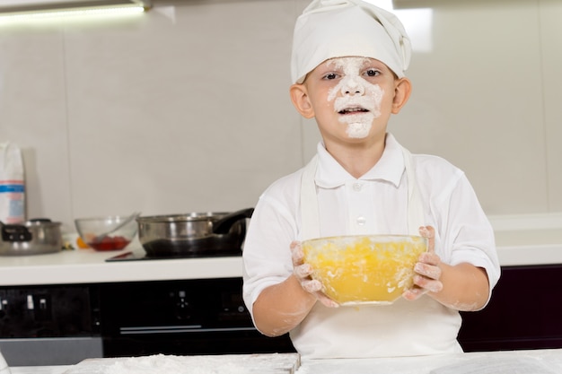 Cute young chef with a face full of flour