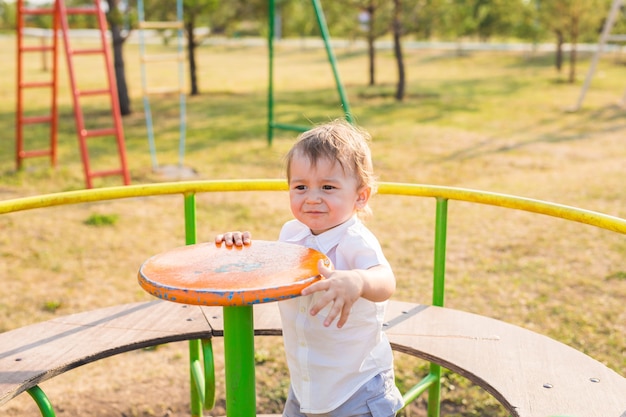 Cute young child boy or kid playing on playground.