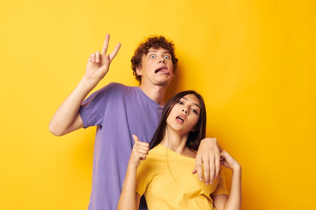 Cute young couple in colorful tshirts posing friendship fun isolated background unaltered