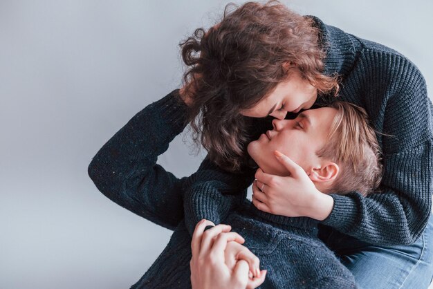 Cute young couple kissing each other indoors in the studio