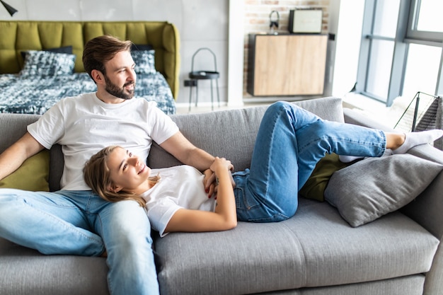 Cute young couple relaxing on couch at home in the living room