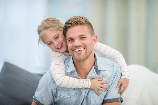 Cute young daughter on a piggy back ride with her dad