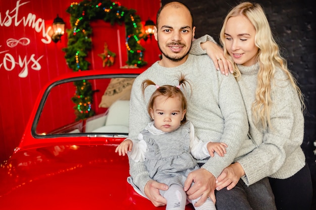 Cute young family  dad mom and baby girl with Christmas