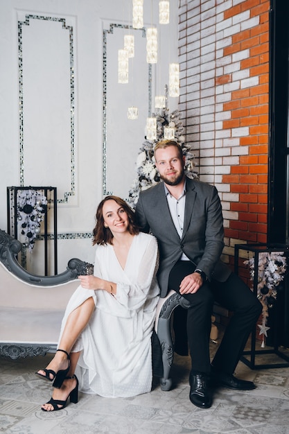 Cute young family husband and wife at the Christmas tree