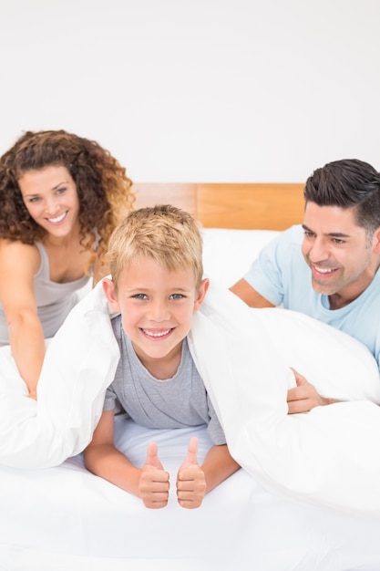 Foto carino giovane famiglia scherzare sul letto