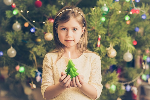 彼女の手にキャンドルでクリスマスのかわいい若い女の子