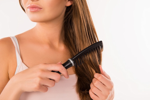 Cute young girl combing her hair