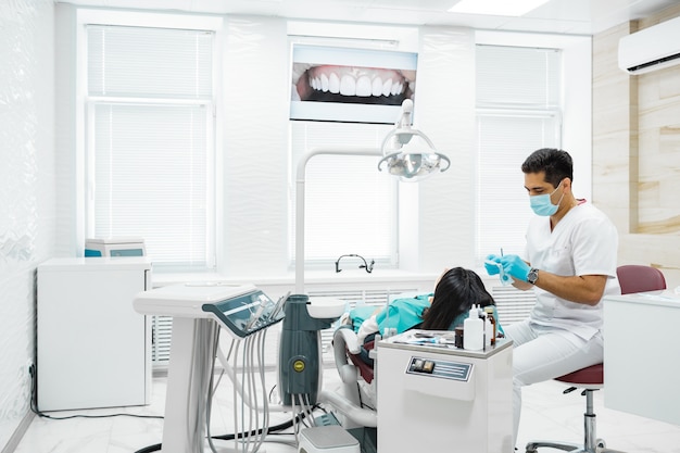 Cute young girl is being examined by the dentist