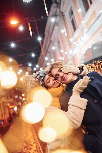 Cute young girl makes surprise to her boyfriend by walking behind him.