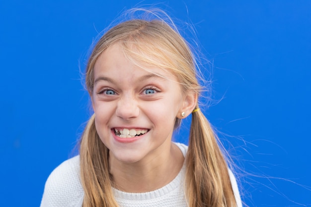 Cute young girl making funny face. Copy space.