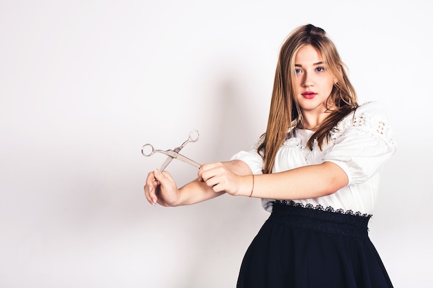 Cute young girl posing with scissors in her hands.