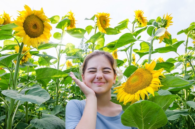 Cute young girl among sunflowers