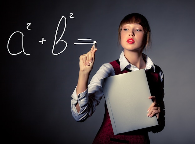 Симпатичная молодая девушка учитель написать математическую формулу