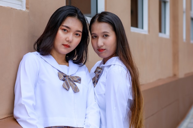 日本、韓国スタイルの女子高生ユニフォーを身に着けているキュートで若い女の子