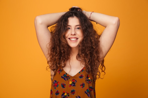 Cute young lady standing isolated over yellow wall