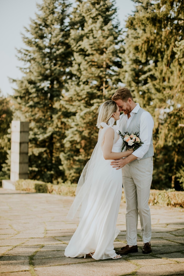 Photo cute young newlywed couple standing in the park