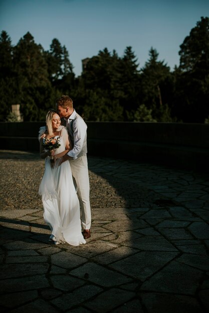 Cute young newlywed couple standing in the park